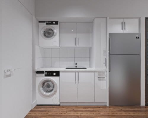White cabinets, washing machine, faucet, and a gray refrigerator